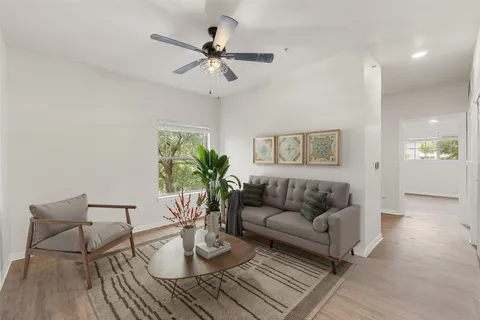 a living room with furniture and a wooden floor