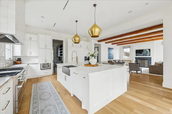 a large white kitchen with lots of counter space and stainless steel appliances