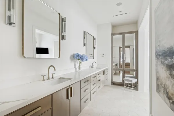 a bathroom with double sink and two mirror