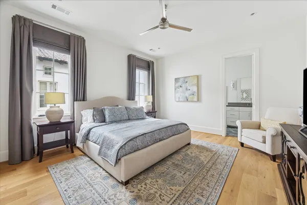 a spacious bedroom with a bed a table and painting on the wall