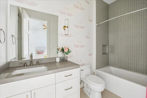 a bathroom with a granite countertop sink a toilet and shower