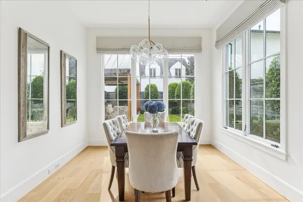 a dining room with furniture large windows and a chandelier