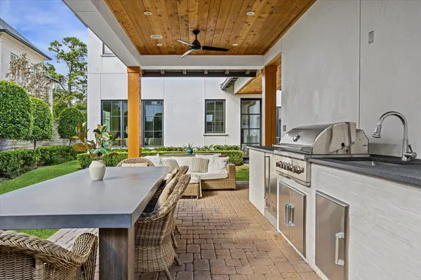 a view of a patio with a table chairs and a barbeque