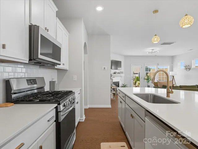 a kitchen that has a sink and a stove top oven