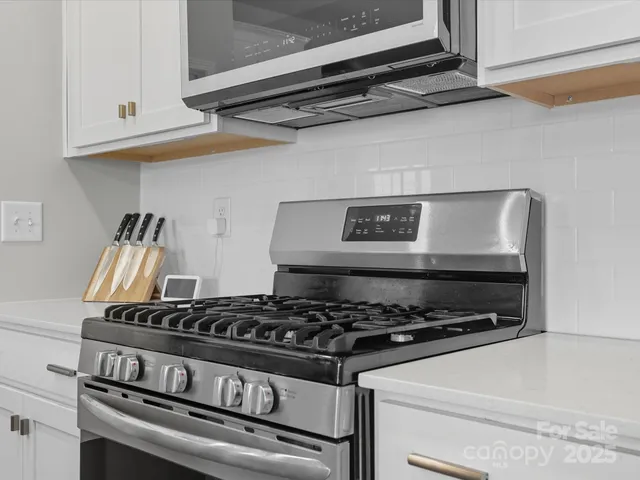 a stove top oven sitting inside of a kitchen