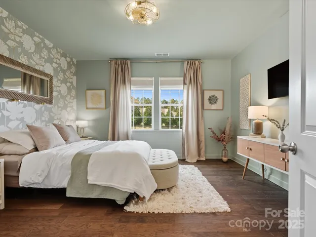 a bedroom with a bed wooden floor and window