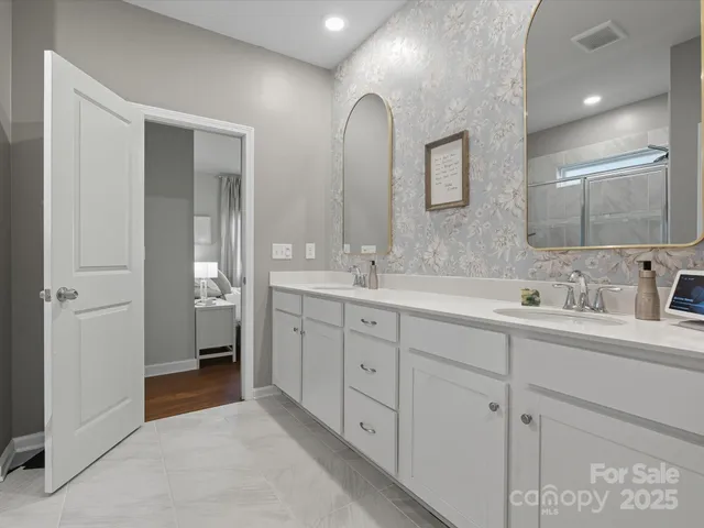 a spacious bathroom with double sink and a mirror