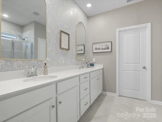 a spacious bathroom with double sink and a mirror