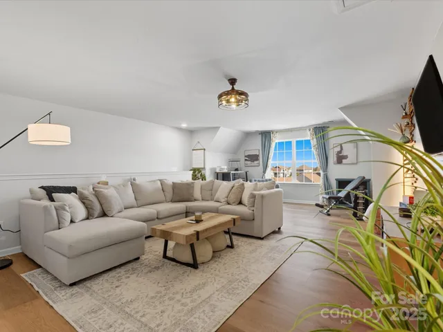 a living room with furniture a flat screen tv and a couch
