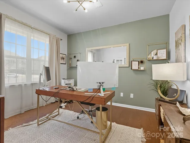 a view of a workspace with furniture and a window