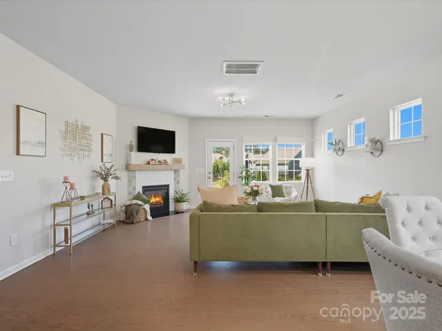 a living room with furniture a fireplace and a flat screen tv