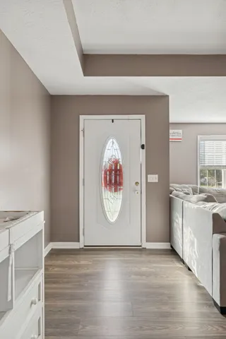 a view of empty room with window and wooden floor