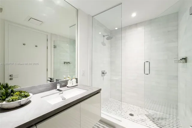 a bathroom with a double vanity sink mirror and shower