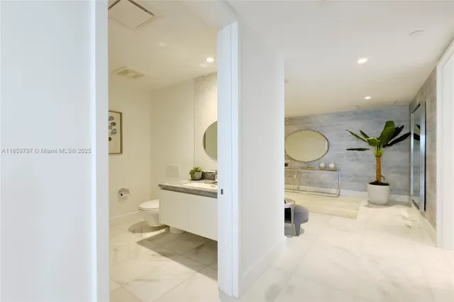 a bathroom with a granite countertop sink a toilet and a mirror