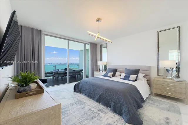 a bedroom with a bed flat screen tv and a large window