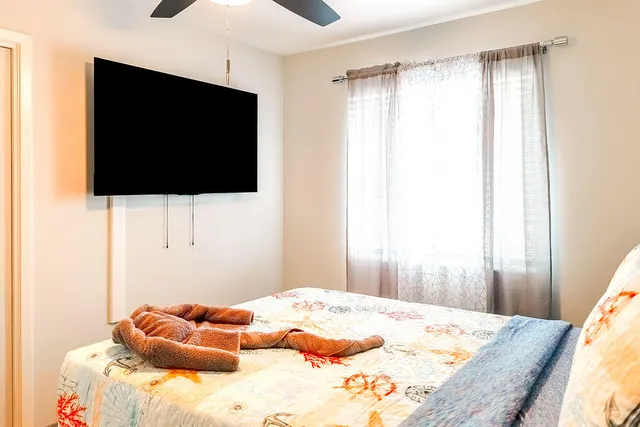 a bedroom with a bed and a flat screen tv