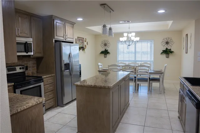 a kitchen with granite countertop a sink stainless steel appliances and cabinets