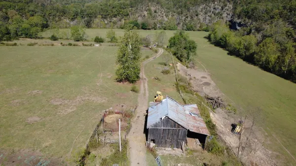 an aerial view of a house with a yard and lake view