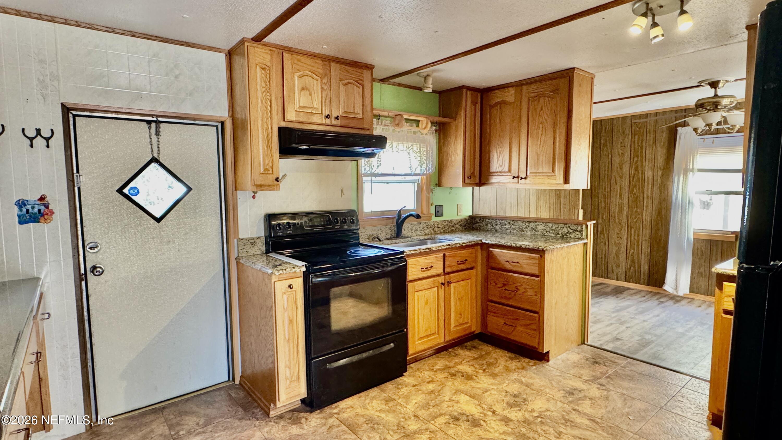 105 Rachel Road Interlachen, FL 32148 - Photo 14 of 24 a kitchen with stainless steel appliances granite countertop a stove a sink and a refrigerator
