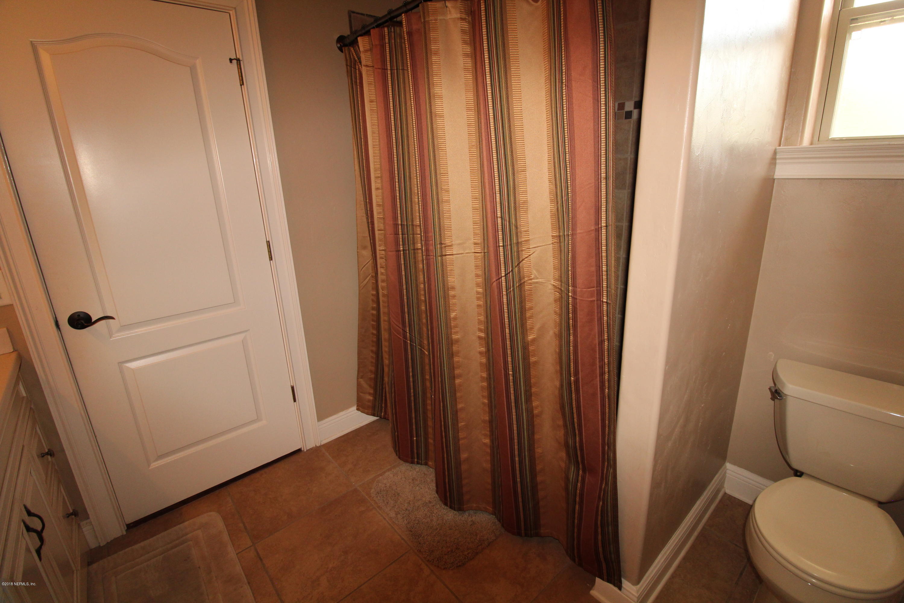 6471 Immokalee Road Keystone Heights, FL 32656 - Photo 68 of 103 a bathroom with a toilet and a shower curtain