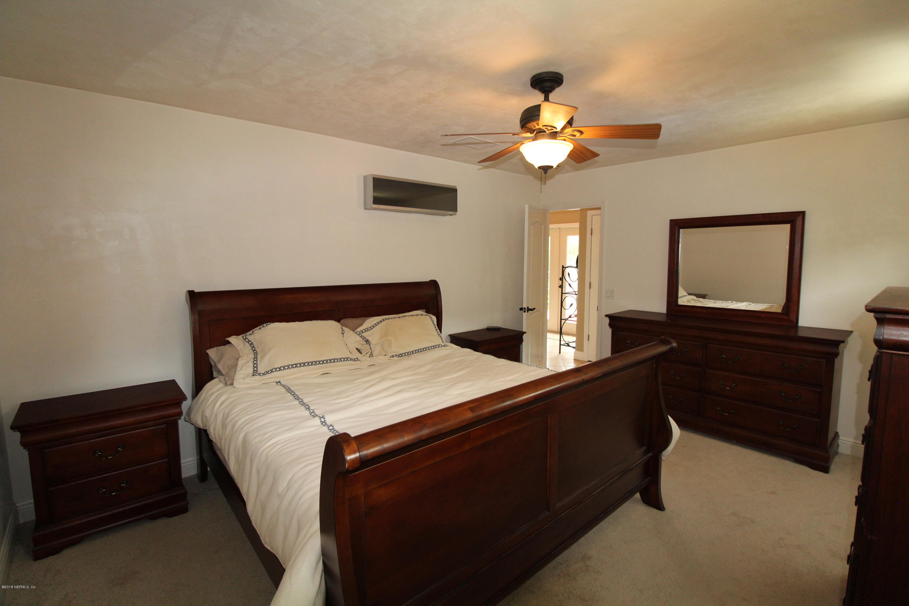 6471 Immokalee Road Keystone Heights, FL 32656 - Photo 81 of 103 a bedroom with a bed and a chandelier