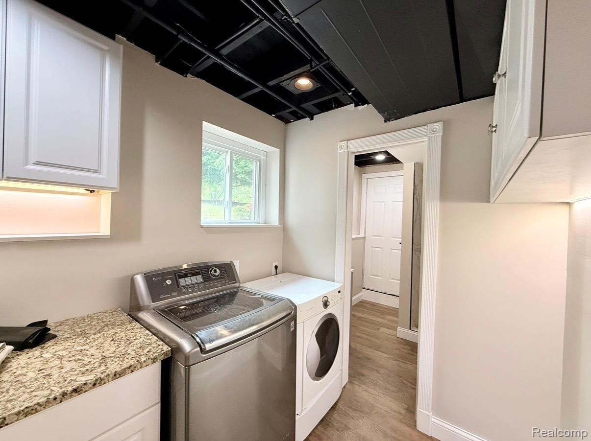 2360 Oklahoma Avenue Rochester, MI 48309 - Photo 34 of 36 Laundry area with light wood-finish flooring, white cabinetry with under-cabinet lighting, and a granite-pattern countertop