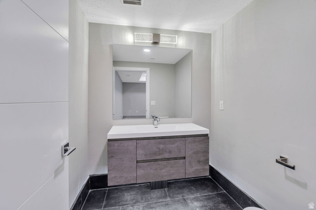 7045 South 300 East Midvale, UT 84047 - Photo 26 of 49 Floating vanity with integrated sink, rectangular mirror, and modern wall sconce lighting