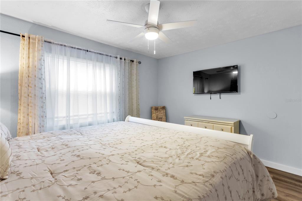 4913 East Temple Heights Road, Unit A Tampa, FL 33617 - Photo 21 of 41 a bedroom with a bed a flat screen tv and a window