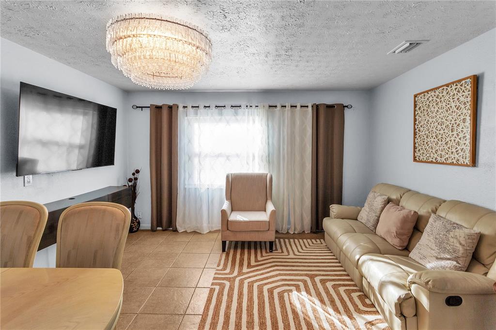 4913 East Temple Heights Road, Unit A Tampa, FL 33617 - Photo 26 of 41 a living room with furniture and a flat screen tv