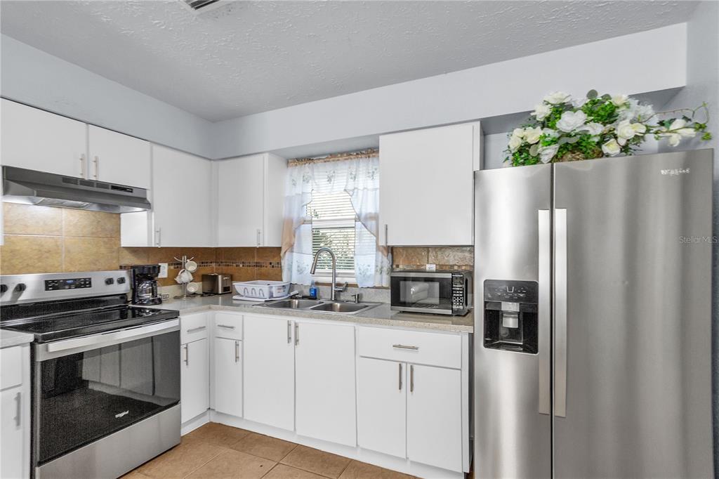 4913 East Temple Heights Road, Unit A Tampa, FL 33617 - Photo 29 of 41 a kitchen with stainless steel appliances a refrigerator sink and stove