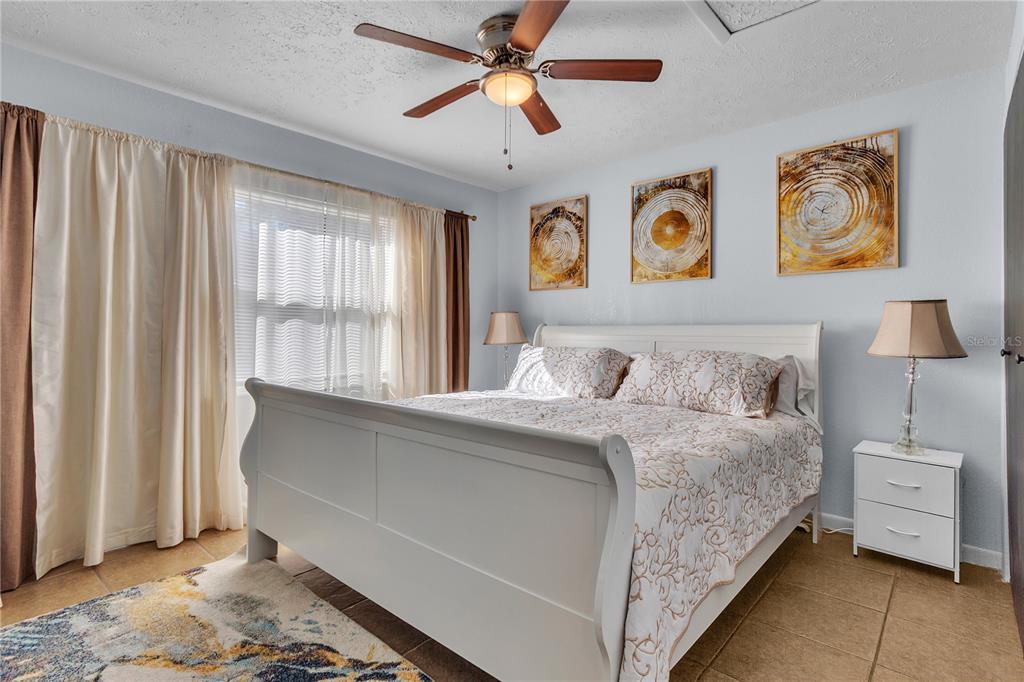 4913 East Temple Heights Road, Unit A Tampa, FL 33617 - Photo 30 of 41 a bedroom with a bed and a chandelier