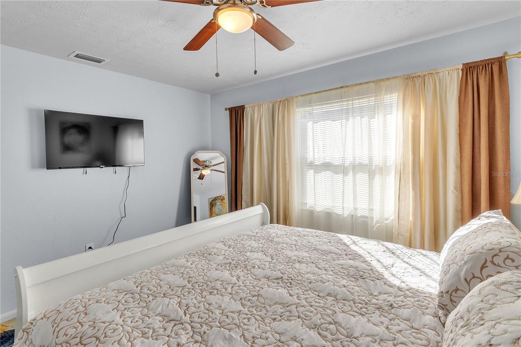 4913 East Temple Heights Road, Unit A Tampa, FL 33617 - Photo 31 of 41 a bedroom with a bed and a flat screen tv