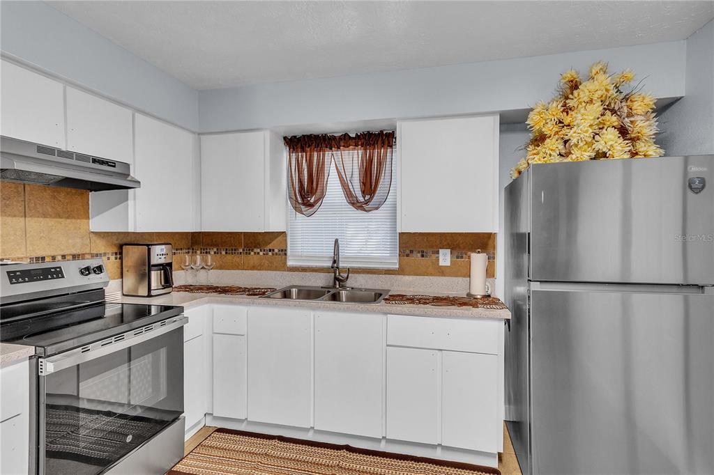 4913 East Temple Heights Road, Unit A Tampa, FL 33617 - Photo 37 of 41 a kitchen with stainless steel appliances granite countertop a refrigerator and a stove top oven