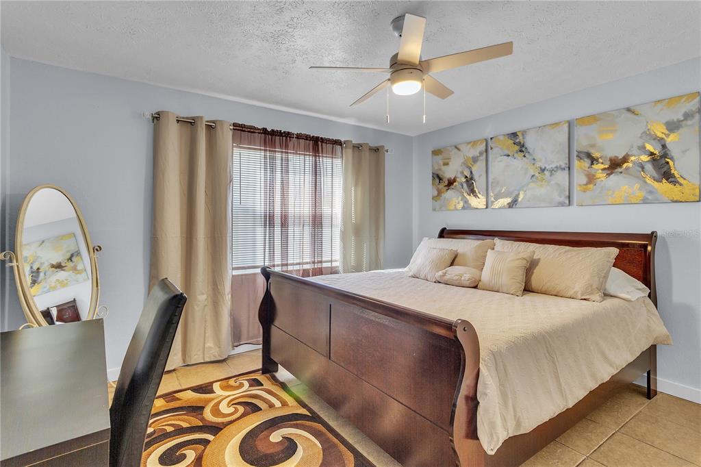 4913 East Temple Heights Road, Unit A Tampa, FL 33617 - Photo 38 of 41 a bedroom with a bed and a chandelier