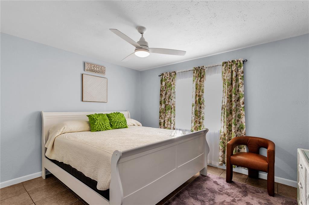 4913 East Temple Heights Road, Unit A Tampa, FL 33617 - Photo 9 of 41 a bedroom with a bed and a chair