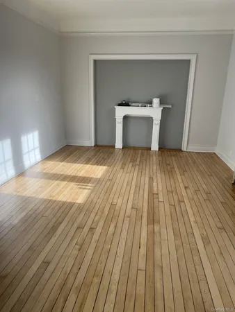 a view of a room with wooden floor and white walls