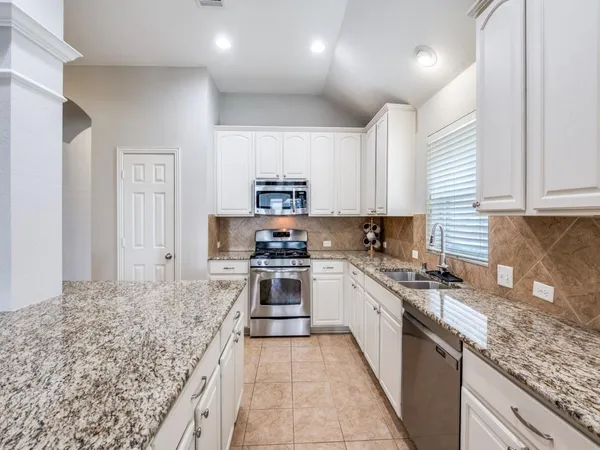 a kitchen with stainless steel appliances granite countertop a stove sink and cabinets