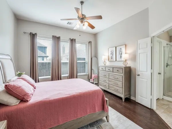 a bedroom with a bed a dresser and a chandelier
