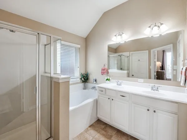 a bathroom with a tub a sink and mirror