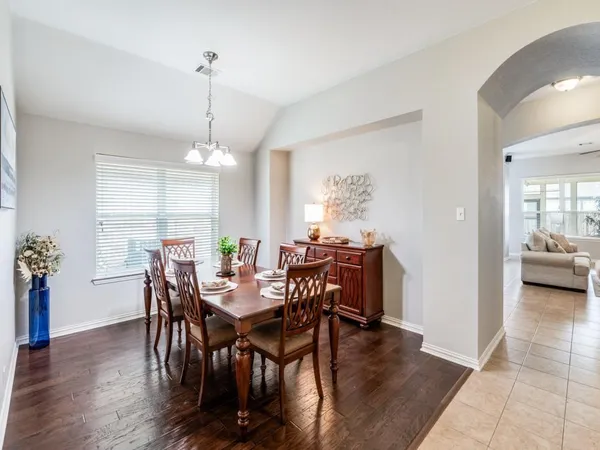 a view of a dining room and livingroom with furniture wooden floor a chandelier
