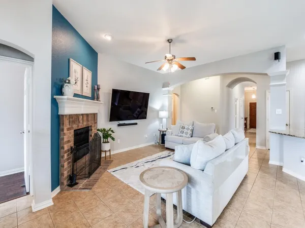 a living room with furniture a fireplace and a flat screen tv
