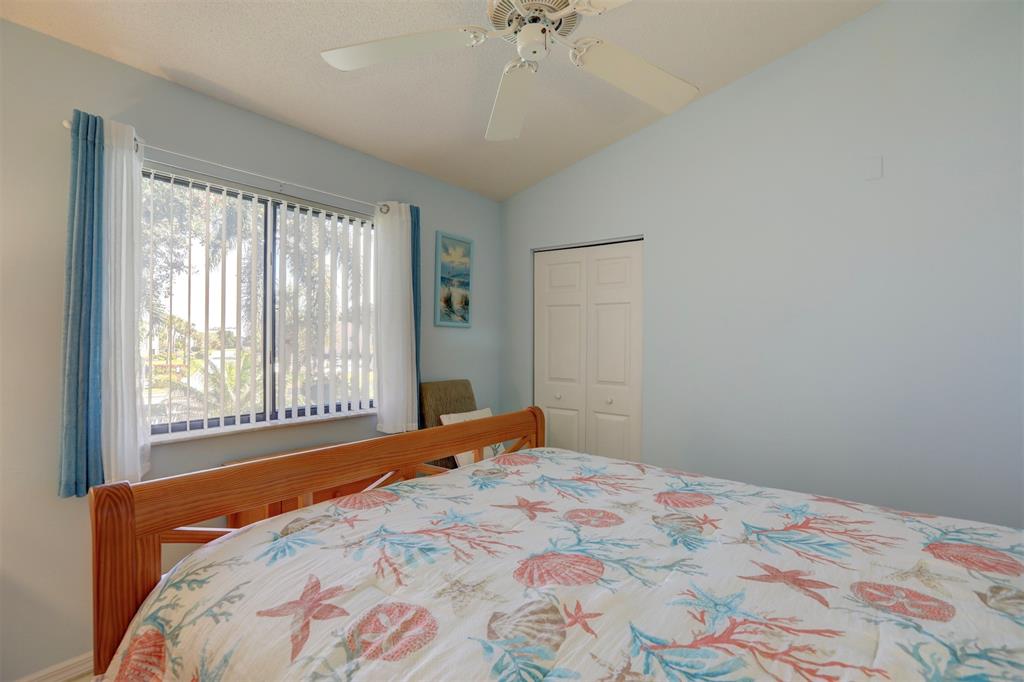 9635 Riverside Drive Sebastian, FL 32958 - Photo 26 of 58 a bedroom with a large bed and a chandelier