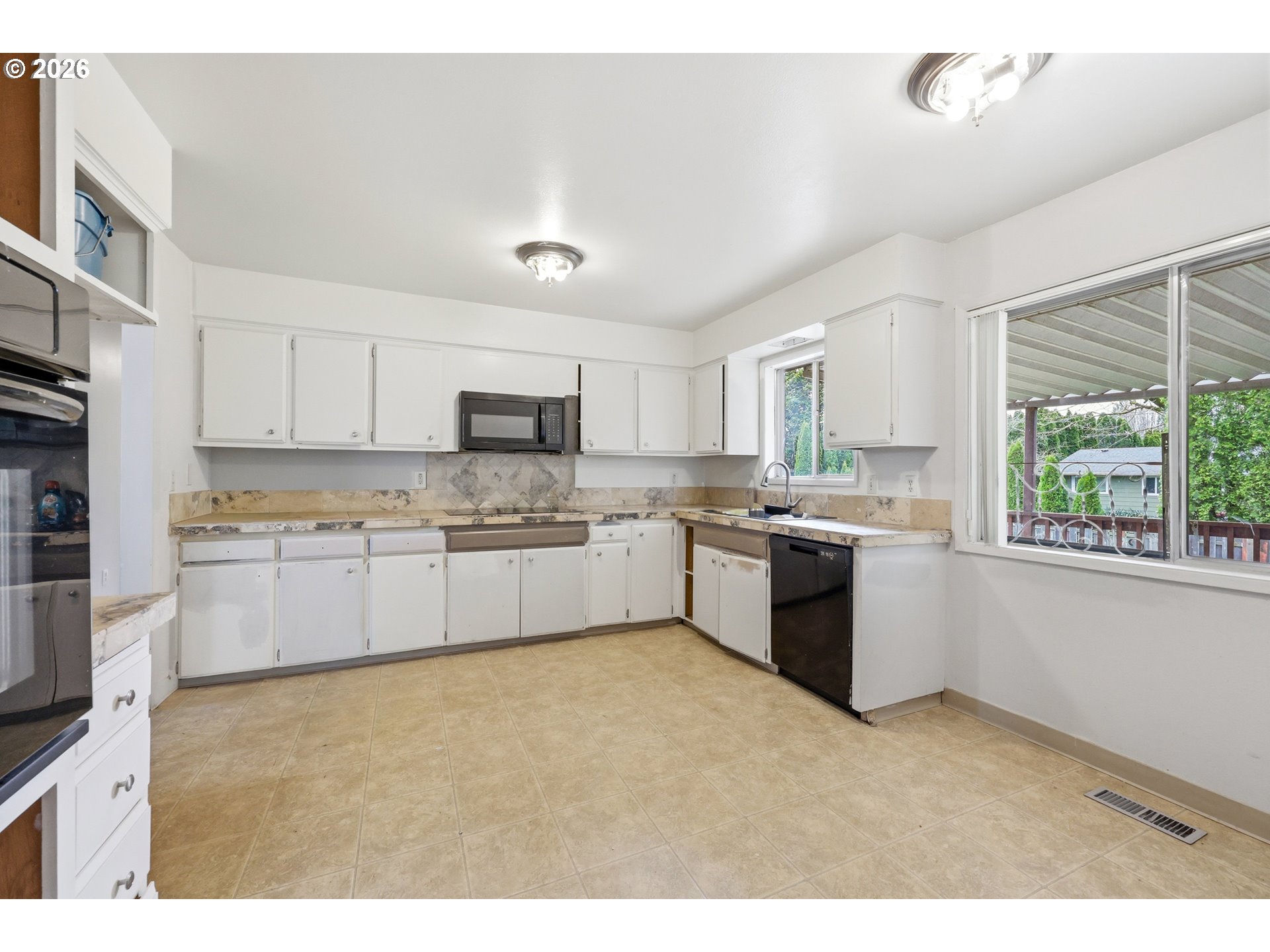 205 Southeast Olvera Avenue Gresham, OR 97080 - Photo 9 of 13 a large kitchen with stainless steel appliances granite countertop a stove a sink dishwasher a refrigerator and white cabinets with wooden floor