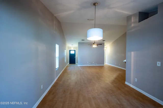 a view of empty room with wooden floor