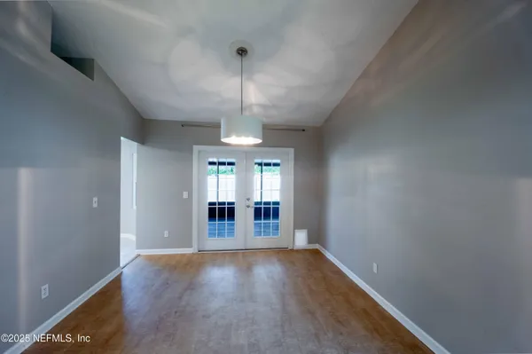 an empty room with stairs and wooden floor