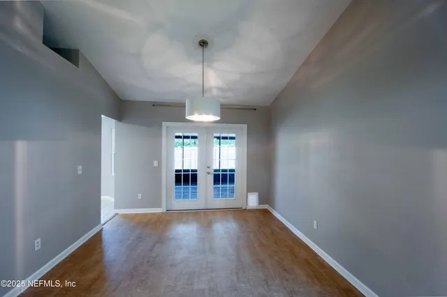 an empty room with stairs and wooden floor