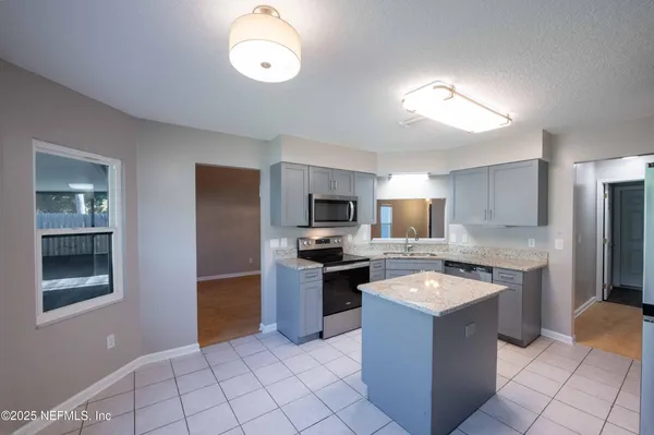 a large kitchen with cabinets and stainless steel appliances