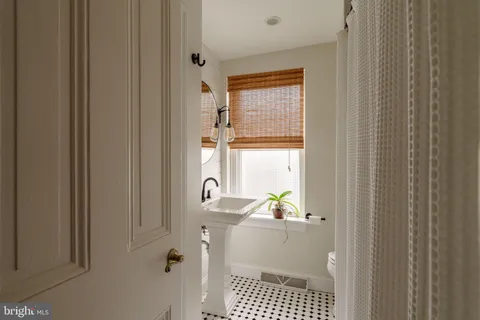 a bathroom with a sink a toilet and a window
