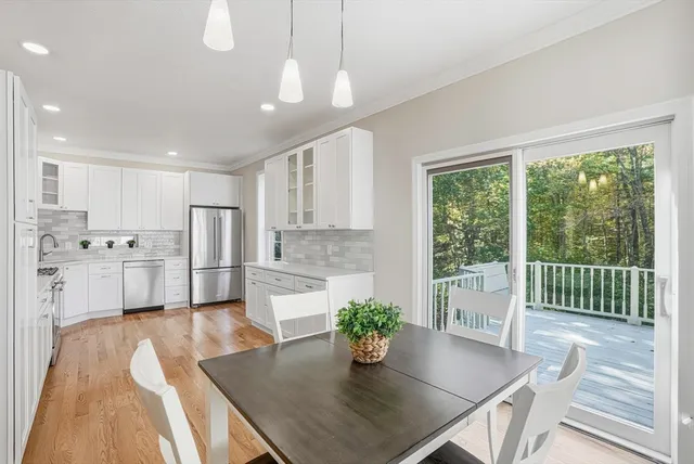 a kitchen with a table chairs refrigerator and microwave