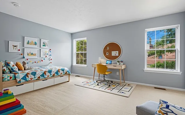 a bed room with a bed a painting on the wall and a window